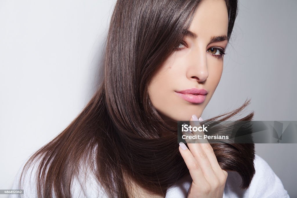 hair beauty beautiful young woman holding her healthy and shiny hair, studio white Women Stock Photo