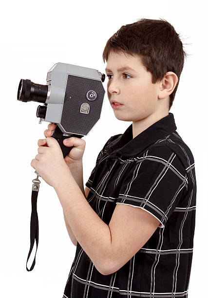 istock young boy with old vintage analog 8mm camera 486812609