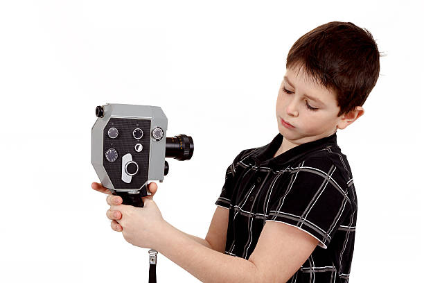 istock young boy with old vintage analog 8mm camera 486812617