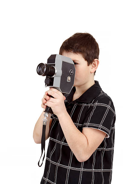 istock young boy with old vintage analog 8mm camera 486812633