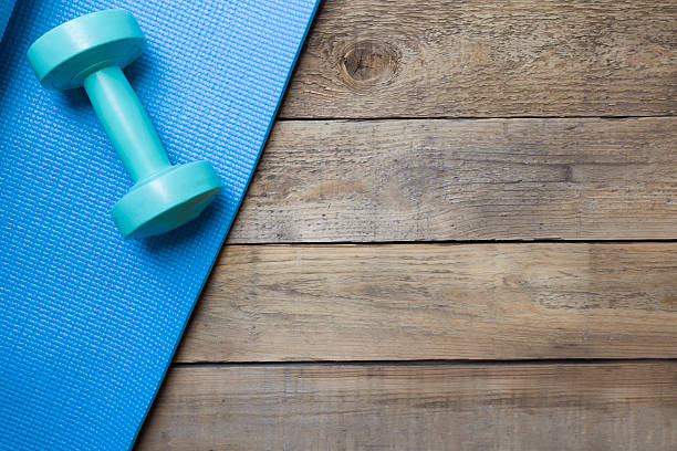 istock dumbbell and yoga mat on wood table 486814244