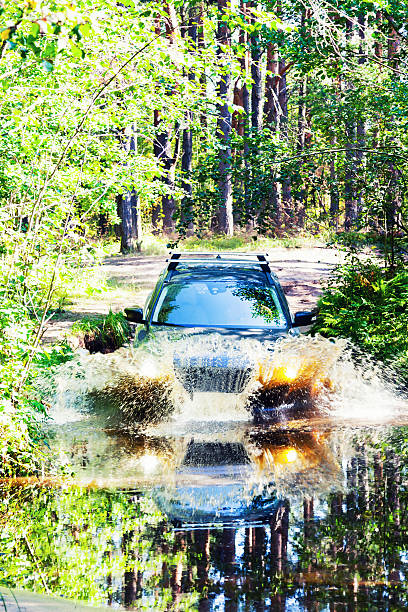 istock Car moving through a large puddle in the woods 486819056