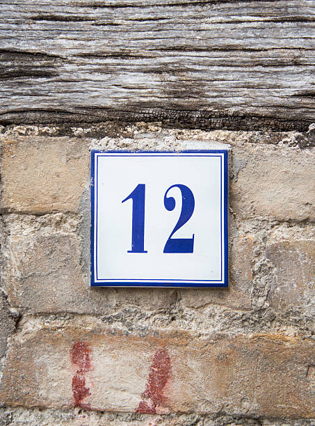 istock Number twelve on the grey stone wall 486824296