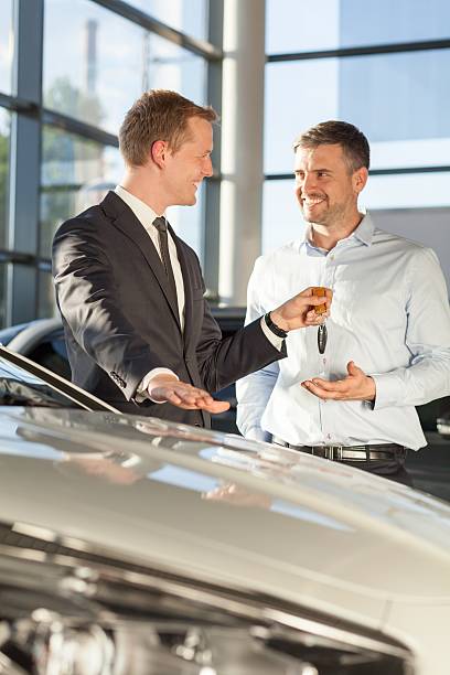 istock Car dealer giving client keys 486825360