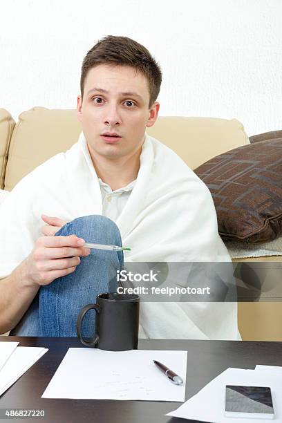 Ill Male Student Having Headache Covered With White Blanket Stock Photo - Download Image Now