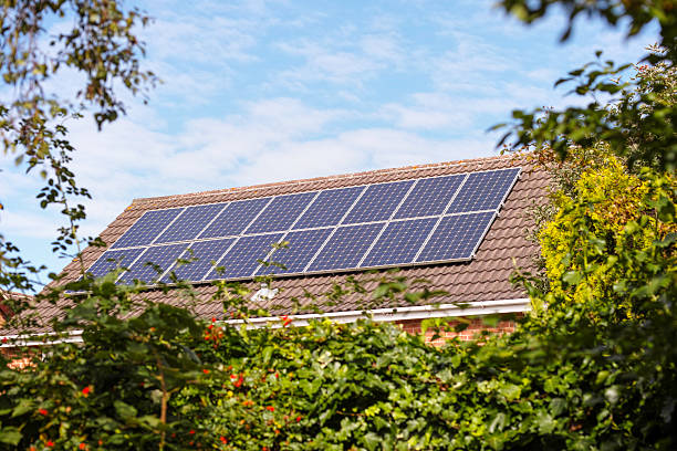 Suburban house with solar panels. English suburban house with solar panels on the roof. solar panels on the roof of building in a city stock pictures, royalty-free photos & images