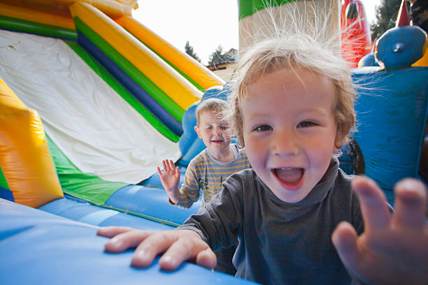 les petits enfants sur un trampoline. - inflatable slide sliding child photos et images de collection