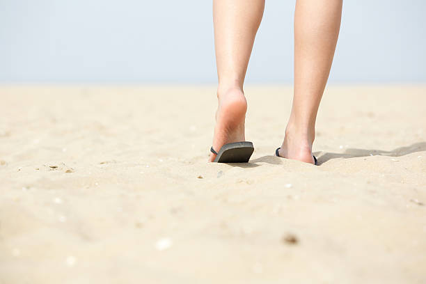 低角度の女性のビーチへも徒歩ですぐ - flip flop human foot sand women ストックフォトと画像