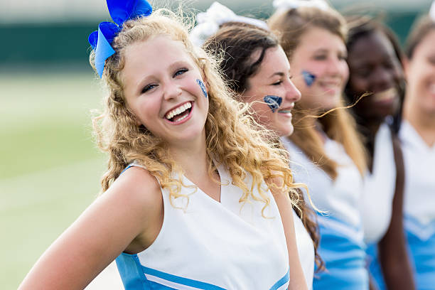istock Team of high school cheerleaders cheering at sporting event 486834344