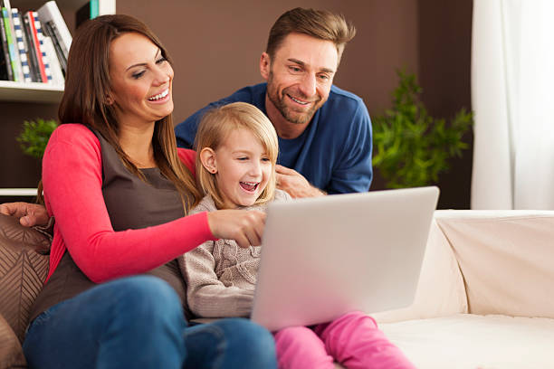 istock Family laughing together and using laptop at home 486834571