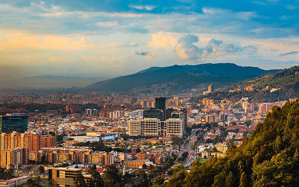 Bogota, Colombia: High Angle View Of Bario de Usaquén From The Heights Of La Calera On The Andes Mountains At Sunset Time The Barrio de Usaquen viewed from the heights of La Calera in  the capital city of Bogota, Colombia in South America at sunset time.  The setting sun hits the buildings both tall and small at an oblique angle.  The road that can be seen in the foreground is Carrera Septima; traffic is congested because offices have just closed.  To the left of the photo is some smog. In the distance, are the always present Andes Mountains.  Horizontal format; copy space. andes photos stock pictures, royalty-free photos & images