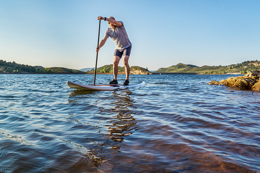 stand up paddling workout on Horsetooth Reservoir at foothills of Rocky Mountains near Fort Collins, Colorado, summer scenery