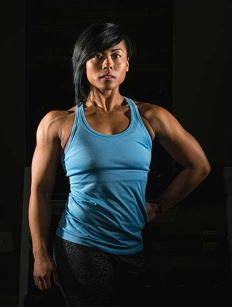 istock Portrait of Confident Female Body Builder Flexing Muscles 486837907