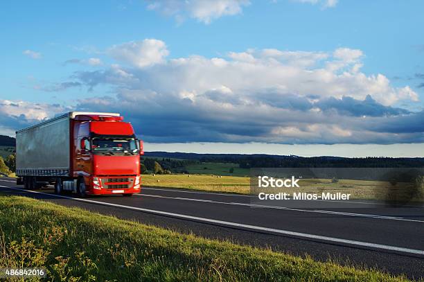 Rural Landscape With Road And Moving Red Truck Stock Photo - Download Image Now - 2015, Agricultural Field, Agriculture