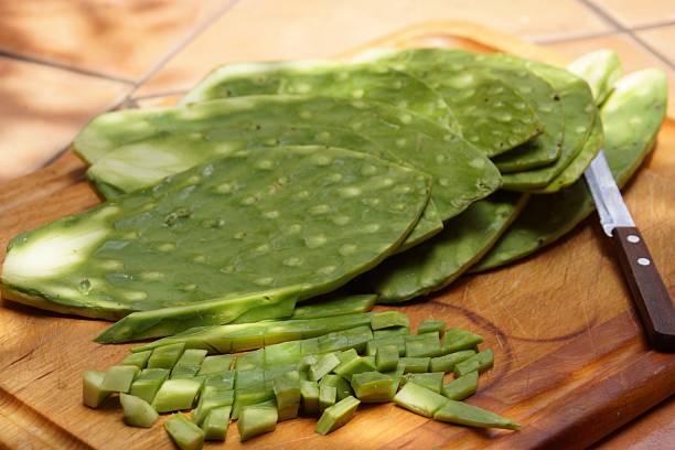 Nopales on a cutting board Nopales are a common and very healthy vegetable in Mexico. They are the leaves of the opuntia ficus-indica cactus They are eaten cooked, baked and even raw.  prickly pear cactus stock pictures, royalty-free photos & images