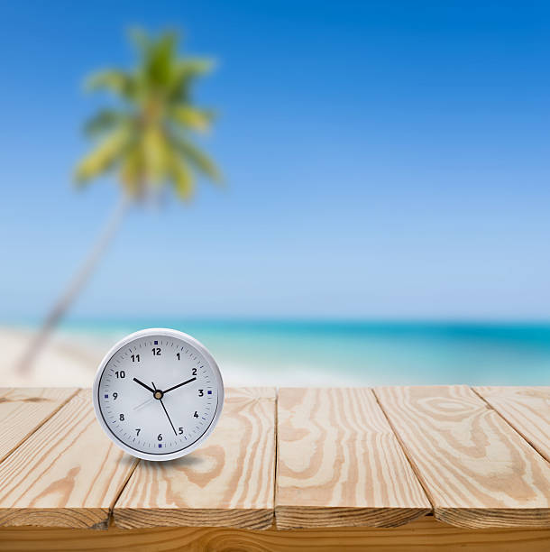 istock Clock on wood table and blue sea background 486843594