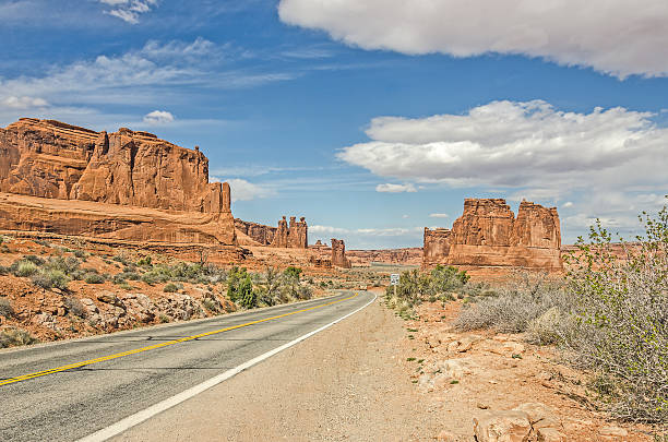 Entrada Sandstone Formations Unique landscape of entrada sandstone formations along a main road in Arches National Park single yellow line sunlight usa utah stock pictures, royalty-free photos & images