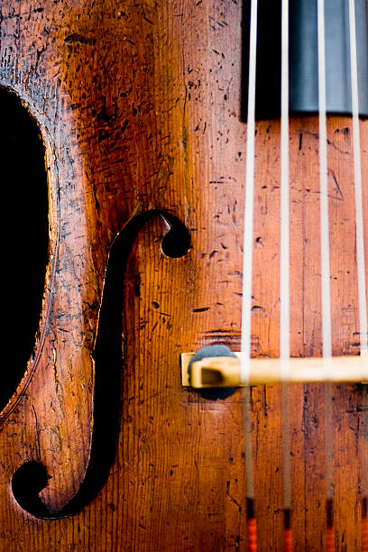 Cello Closeup of old cello with scratches, nicks, and chamber orchestra stock pictures, royalty-free photos & images