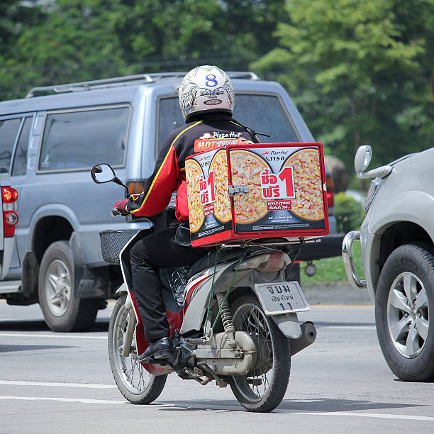 homem de serviço de entrega de pizza motercycle porte uma cabana de empresa - pizza hut asia pizza restaurant imagens e fotografias de stock