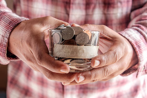 istock man holding money jar with coins close up 486854262