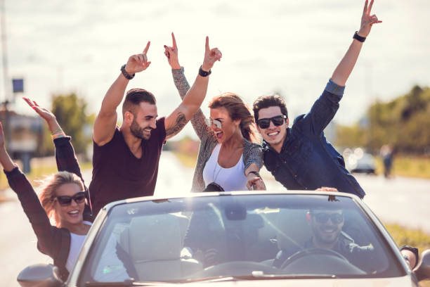 istock Excited group of friends having fun in a convertible. 486855228