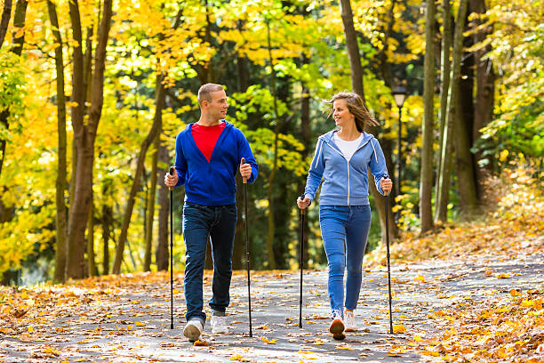 zdrowy tryb życia-młodzi ludzie nordic walking na park - nordic walking zdjęcia i obrazy z banku zdjęć