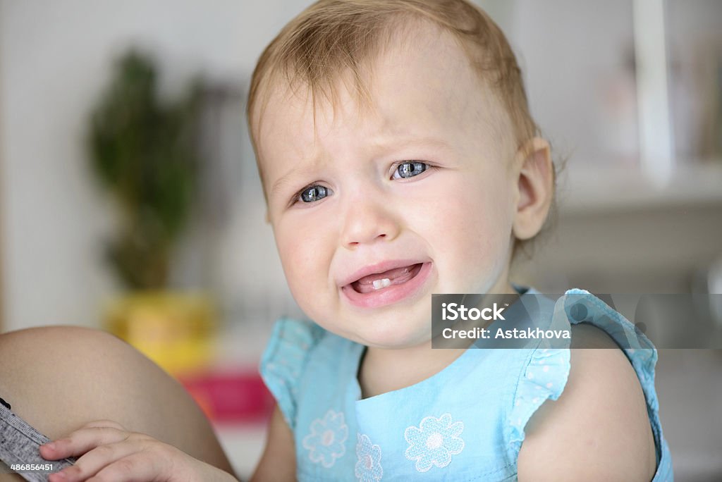 small baby crying small baby is crying hard. Tears stream down her cheeks Teething Toy Stock Photo