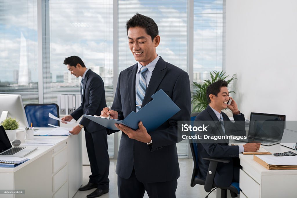 Everything under control Vietnamese businessman and his clones working in the office Cloning Stock Photo