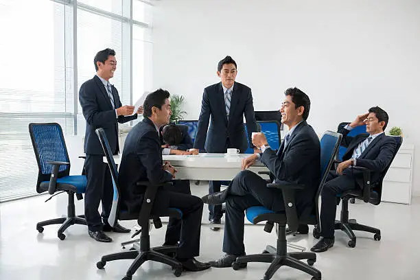 Composite image of entrepreneur having business meeting with his clones