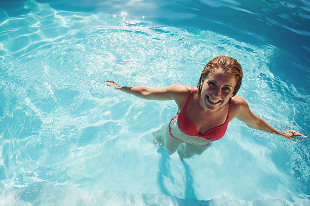 istock Girl standing in a swimming pool smiling 486858283