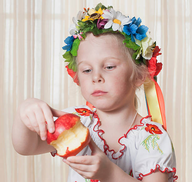 A Menina de 4 anos come Maçã vermelha - fotografia de stock