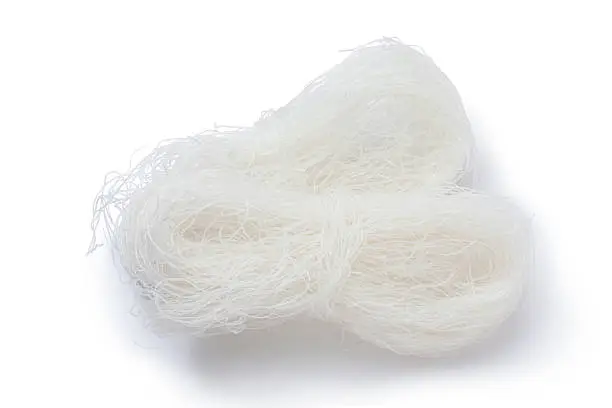 Dry rice vermicelli noodles on white background