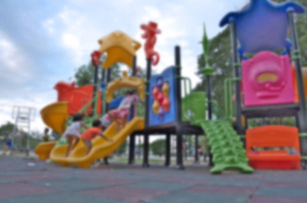 Defocused and blur image of children playing at a playground for background usage