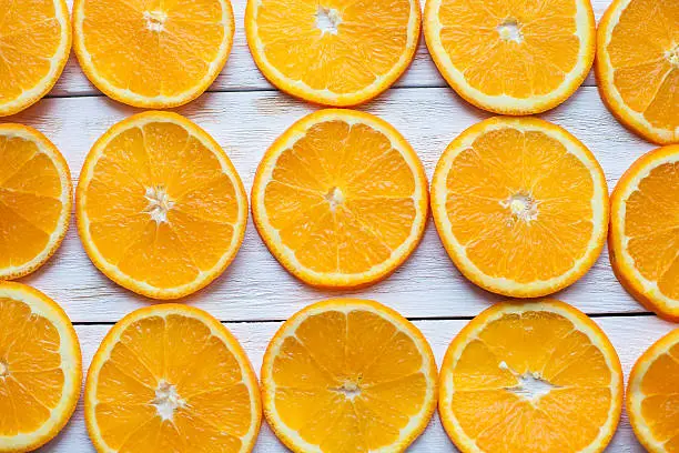 Background with citrus-fruit of orange slices on white wooden background