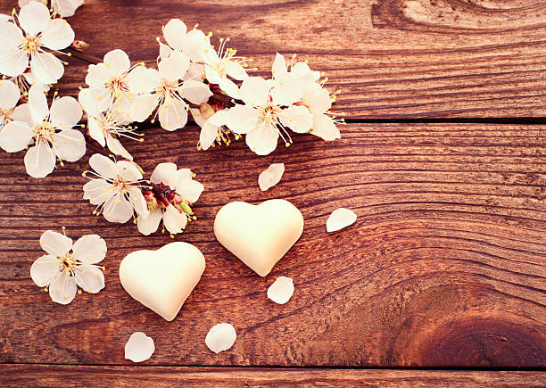 istock Flowering branch with white delicate flowers on wooden surface 486862897