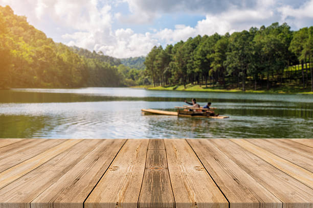 Wooden board empty table blurred lake in fores background. stock photo