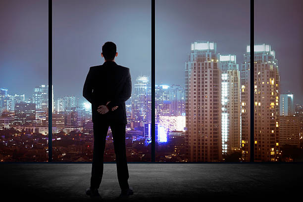 istock Man standing in his office looking at the city 486864352