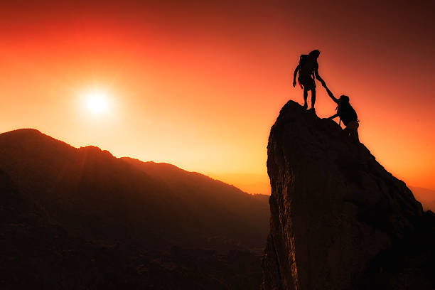 equipe de alpinistas ajudá-lo a conquistar o topo - climbing clambering mountain silhouette - fotografias e filmes do acervo