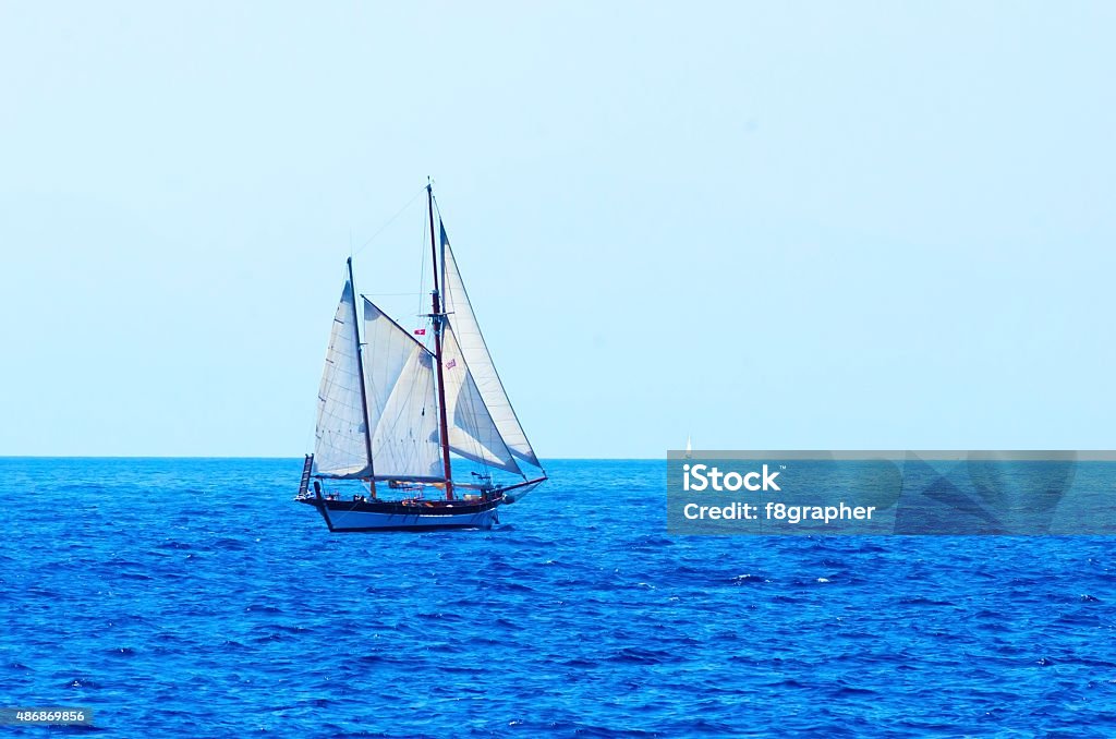 Sailing A sailing boat crossing the sea/ocean In Front Of Stock Photo
