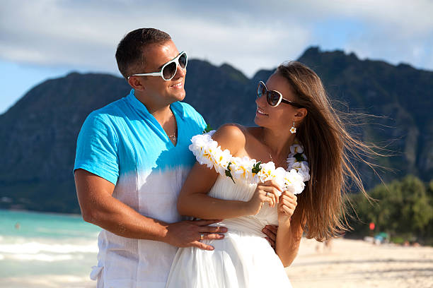 Young couple in love feeling happy on the Hawaiian beach stock photo