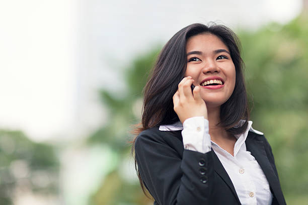 jovem mulher de negócios ao telefone - asian ethnicity philippines women beauty - fotografias e filmes do acervo