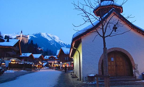 Gstaad Switzerland winter shoppers on snowy street at twilight stock photo