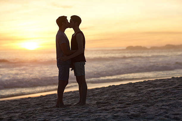 Sunset kiss Shot of a young couple kissing on the beach at sunsethttp://195.154.178.81/DATA/i_collage/pu/shoots/805559.jpg gay men kissing men silhouette stock pictures, royalty-free photos & images