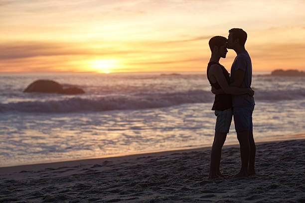 完璧なビーチの日付になっています。 - gay man homosexual men kissing ストックフォトと画像