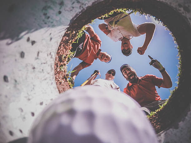 istock Point Of View Golf Players and Ball From Inside Hole 486876126