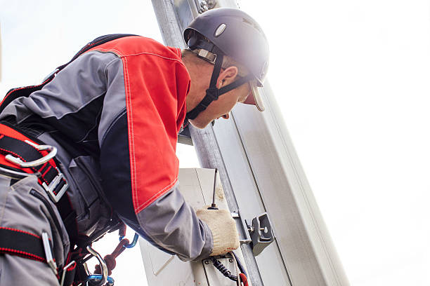 installation of telecommunication equipments maintenance engineer installs transmitter to the telecommunications tower mobile phone mast stock pictures, royalty-free photos & images