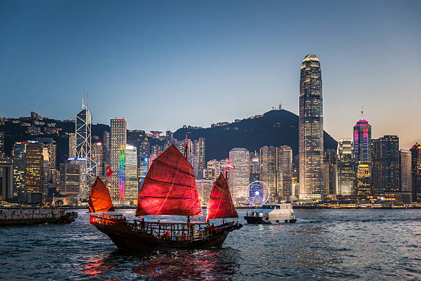 traditionelle dschunke in der dämmerung - hong kong cityscape flowing water built structure stock-fotos und bilder