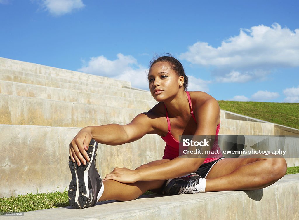 Healthy Young Pretty Mixed Race Woman Stretching Her Leg healthy young pretty mixed race woman stretching her leg during exercise in grass right before a work out. Horizontal shot.file_thumbview_approve.php?size=1&id=20203006 20-24 Years Stock Photo