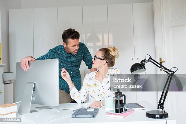 Woman And Man Working In An Office Stock Photo - Download Image Now - Businessman, Computer Monitor, Desk