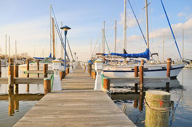 Cambridge Yacht Club Pier Sailboats and motor lunches line the pier at the Cambridge Maryland yacht club on a winter morning Marina stock pictures, royalty-free photos & images